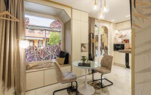 a living room with a table and chairs and a window at Armoni Laguna Romantic Apartment - Private Infrared Sauna & Bathtub near Flexum Thermal Spa in Mosonmagyaróvár