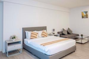 a bedroom with a large bed and a couch at GRAND PA Hotel&Resort Lamphun Chiang Mai in Lamphun