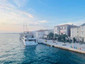 a boat is docked in the water next to buildings at Apartments Vozab in Pag