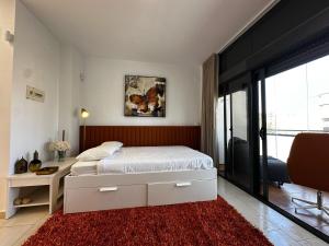 Schlafzimmer mit einem Bett und einem roten Teppich in der Unterkunft Magnificent Studio Isla Cristina in Isla Cristina