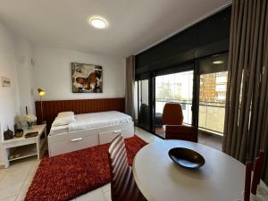 ein Hotelzimmer mit einem Bett und einem Tisch sowie einem Zimmer in der Unterkunft Magnificent Studio Isla Cristina in Isla Cristina