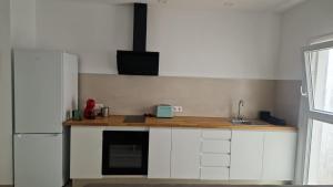 a kitchen with white cabinets and a wooden counter top at Hugo 2 in Cala Ratjada