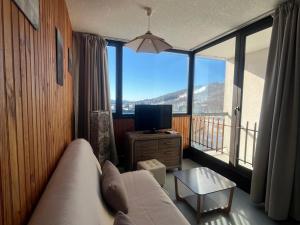 un salon avec un canapé et une grande fenêtre dans l'établissement Appartement familial 6 pers. à Super Besse, proche pistes - FR-1-814-131, à Besse-et-Saint-Anastaise 4 autres photos