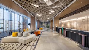 a lobby with couches and chairs in a building at Holiday Inn Shanghai Pudong Airport, an IHG Hotel in Shanghai