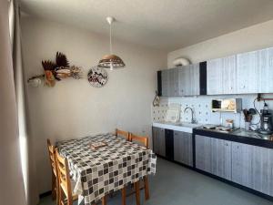 une cuisine avec une table et un évier et une table et des chaises dans l'établissement Appartement familial 6 pers. à Super Besse, proche pistes - FR-1-814-131, à Besse-et-Saint-Anastaise