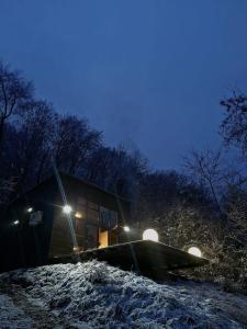 a small cabin in the snow at night at Forest Studio Corunca in Corunca +6 photos