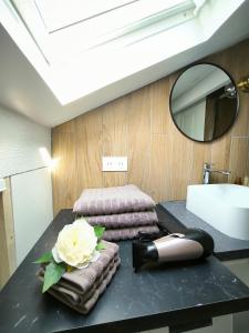a bathroom with a table with towels and a flower on it at Apartement Duplex proche Paris, Aéroport CDG Stade de France Parc Expo Villepinte in Le Blanc-Mesnil