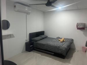 a bedroom with a bed with a teddy bear on it at Hureen chalet hmk in Kangar