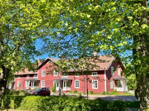 a red house with a car parked in front of it at Fridhem Coursecenter & Guesthouse in Stjärnsund