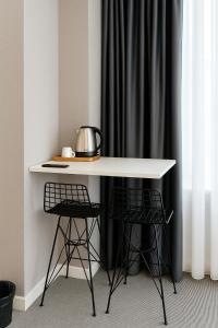 una mesa blanca con 2 sillas y un hervidor de agua. en Blue Point Hotel, en Estambul