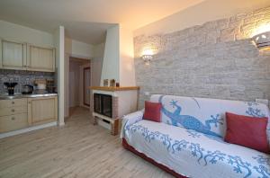 a living room with a couch and a stone wall at L'angolo delle More in Monte Castello di Vibio