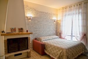 a bedroom with a bed and a fireplace at L'angolo delle More in Monte Castello di Vibio