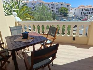 une table et des chaises en bois sur un balcon dans l'établissement NICE 1 BEDROOM APARTMENT LOS CRISTIANOS, à Los Cristianos