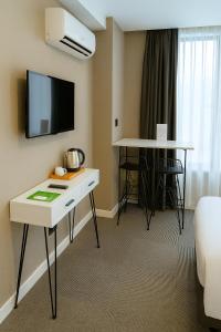 Una habitación de hotel con un escritorio y un televisor en la pared. en Blue Point Hotel, en Estambul