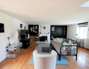 a living room with a couch and a table at LE COSY duplex centre ville in Betton