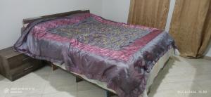 een bed met een paarse deken erop bij appartement T3 équipe in Matriouene