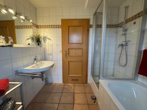 Un baño con bañera, lavabo y ducha. en Oewern Diek App 08, en Wustrow
