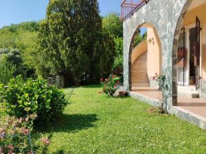 a garden outside a house with an arch and flowers at Cogoleto - Villetta Il Canneto in Cogoleto