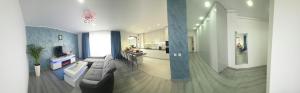 a living room with a couch and a kitchen at Luxury BROthers' Apartment in Alba Iulia