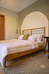 バトゥにあるRumansa Villa Batuの白いシーツと枕が付いた大きなベッドのある寝室