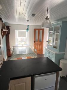 eine Küche mit einem Tisch und einem Bett in einem Zimmer in der Unterkunft Fiddlers Cottage in Springmount