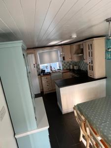 eine kleine Küche mit einem Tisch und einer Arbeitsplatte in der Unterkunft Fiddlers Cottage in Springmount