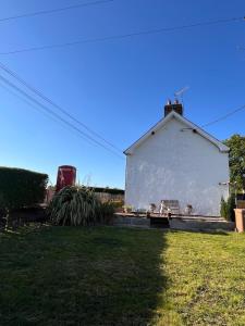 ein großes weißes Gebäude auf einem Grasfeld in der Unterkunft Fiddlers Cottage in Springmount + 10 Fotos