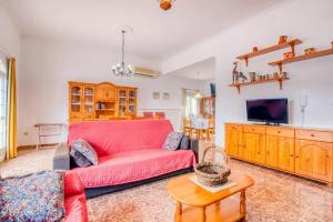 a living room with a red couch and a tv at Family Villa in Benifayó with Year-Round Private Pool in Benifayó