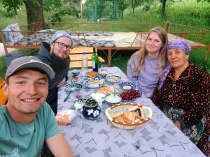 a group of people sitting at a table with food at Muso guesthouse in Yukary-Ukhum +25 photos