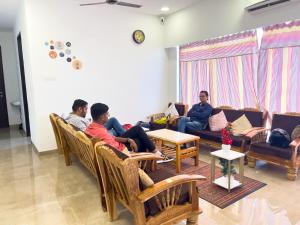 a group of people sitting in a living room at Pinaki Comfort Stay Vile Parle - Near Airport in Mumbai