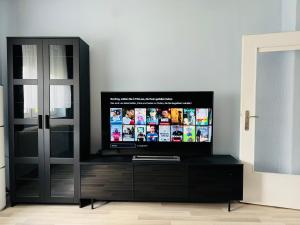 einen Flachbild-TV auf einem schwarzen Entertainment-Center in der Unterkunft Große Ferienwohnung mit Traumküche I 24 h Check in I Free Parking in Bielefeld + 6 Fotos