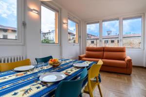 a dining room with a table and chairs and a couch at La Torretta Panorama in Bergamo