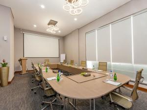 a conference room with tables and chairs and a projection screen at Flora Al Barsha Hotel At The Mall in Dubai