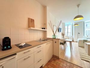 a kitchen with a sink and a living room at Le Fablet, Hyper centre de Rennes in Rennes
