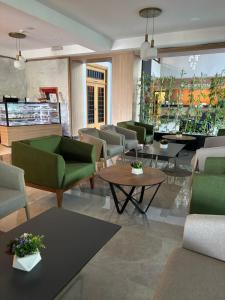 a lobby with green chairs and tables in a store at Sırma Hotel - All Inclusive in Side