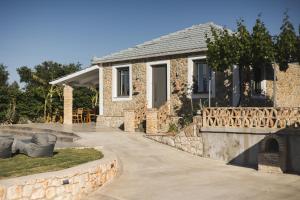ein Steinhaus mit Terrasse und Kamin in der Unterkunft Binios Villa - private pool, walking distance from the Beach in Vasilikos