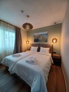 a bedroom with a large bed with two towels on it at Oreades Parthenon Suites in Athens