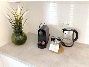 a kitchen counter with a coffee maker and a blender at Neues Küstenjuwel mit erstklassiger Einrichtung direkt am Hafen "Momentic" in Neustadt in Holstein