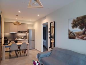 a living room and kitchen with a blue couch at Oreades Parthenon Suites in Athens