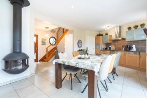 a kitchen with a table with chairs and a fireplace at Villa lumineuse 1km de la plage in Loctudy
