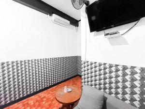 a small room with a table and a tv at Modom Residence in Jakarta