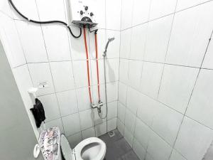 a small bathroom with a toilet and a shower at Modom Residence in Jakarta