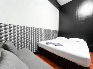 a bed and a couch in a room at Modom Residence in Jakarta +3 photos