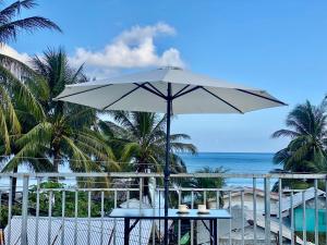 a table with an umbrella on the beach at Casa Vina El Nido in El Nido