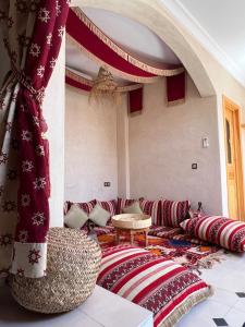 a living room with a couch and red pillows at SurfAppart Morocco in Tamraght Ouzdar