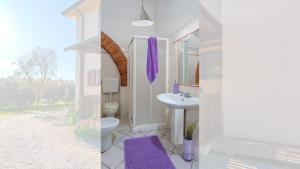 a white bathroom with a sink and a toilet at Podere Santo Signoretto in San Vincenzo