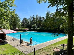 a man standing in front of a large swimming pool at Trompeten-, Posaunen- & Tuba-Appartment in Stolpen in Stolpen