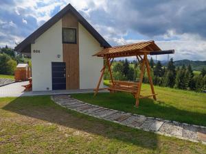 a bench with a gazebo in front of a building at Domek pod lasem in Toporzysko