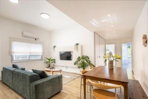 a living room with a couch and a table at Stylish 3BR Apt w Balcony 5 min Walk from Beach with Shelter by Sea N' Rent in Tel Aviv