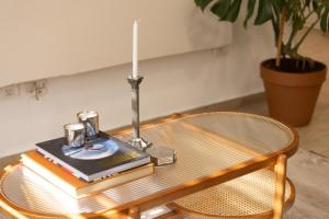 a coffee table with a book and a lamp on it at Stylish 3BR Apt w Balcony 5 min Walk from Beach with Shelter by Sea N' Rent in Tel Aviv